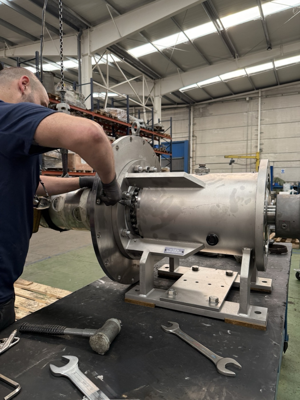 Técnico de ANANTA apretando los pernos de una bomba industrial en el taller