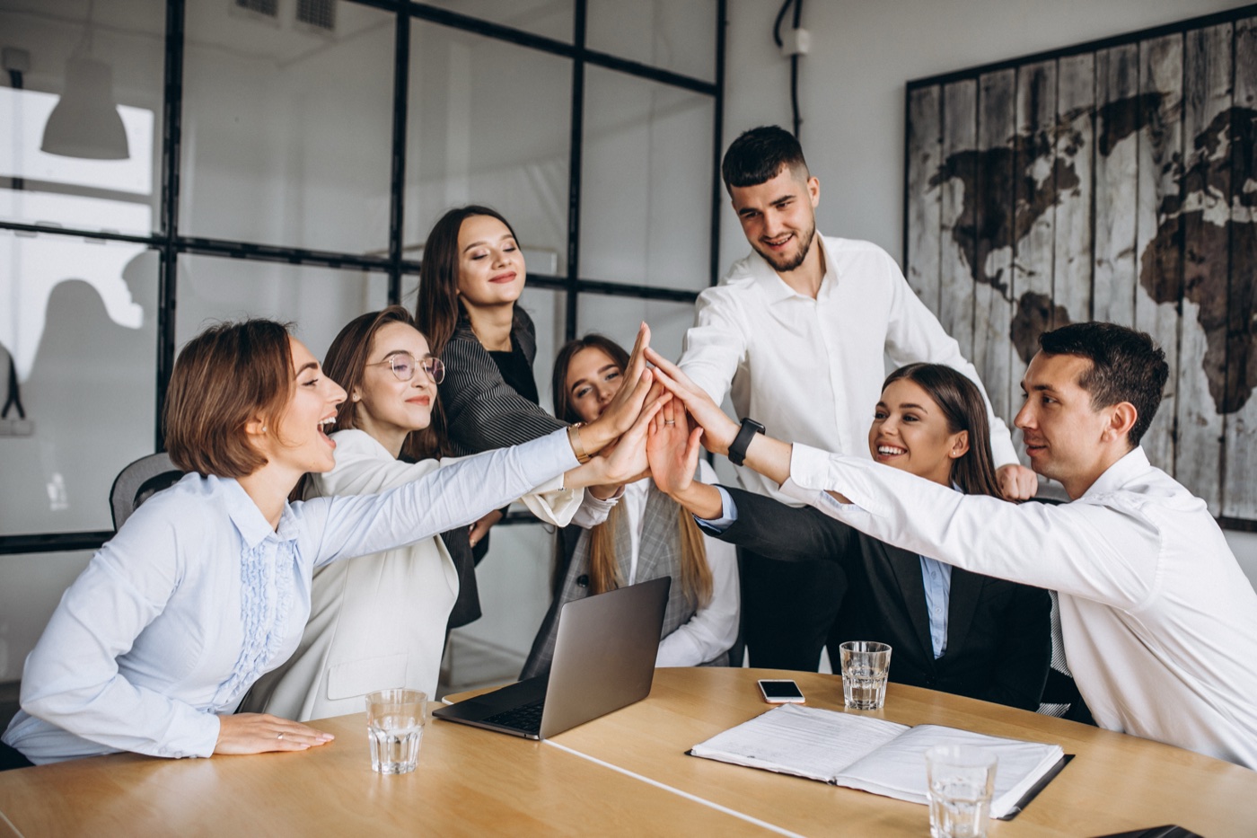 Equipo de ANANTA celebrando juntos alrededor de una mesa de reuniones
