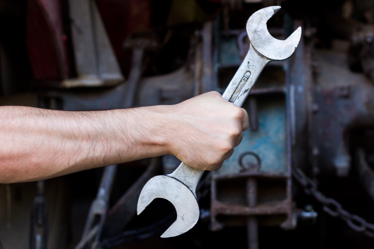 Técnico de mantenimiento industrial sujetando una llave fija ante un equipo